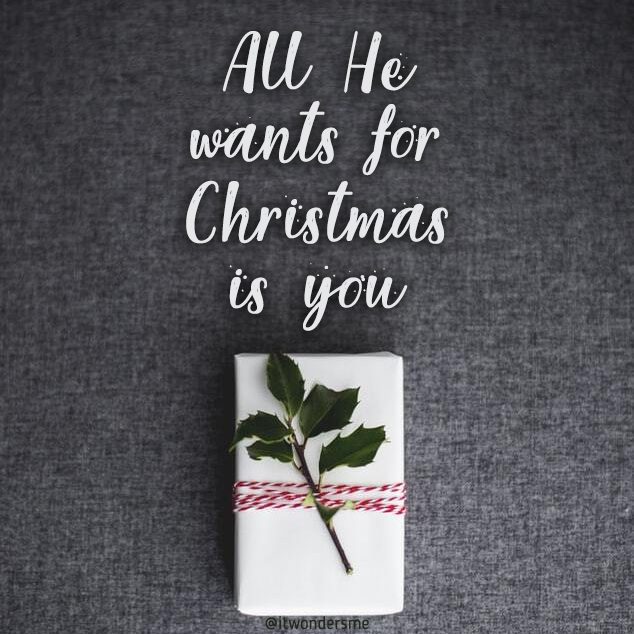 "All he wants for Christmas is you." A wrapped present with a sprig of holly in the ribbon.