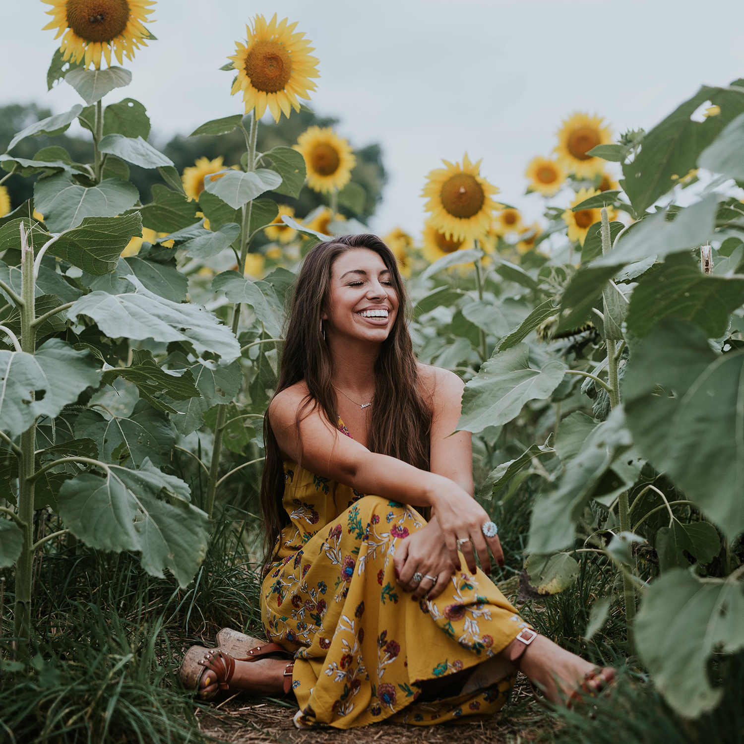 Woman sitting in a sunflower garden by Brooke Cagle via Unsplash